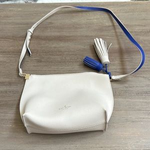 Kate Spade cream crossbody available with tassel strap. Interior is blue lined.